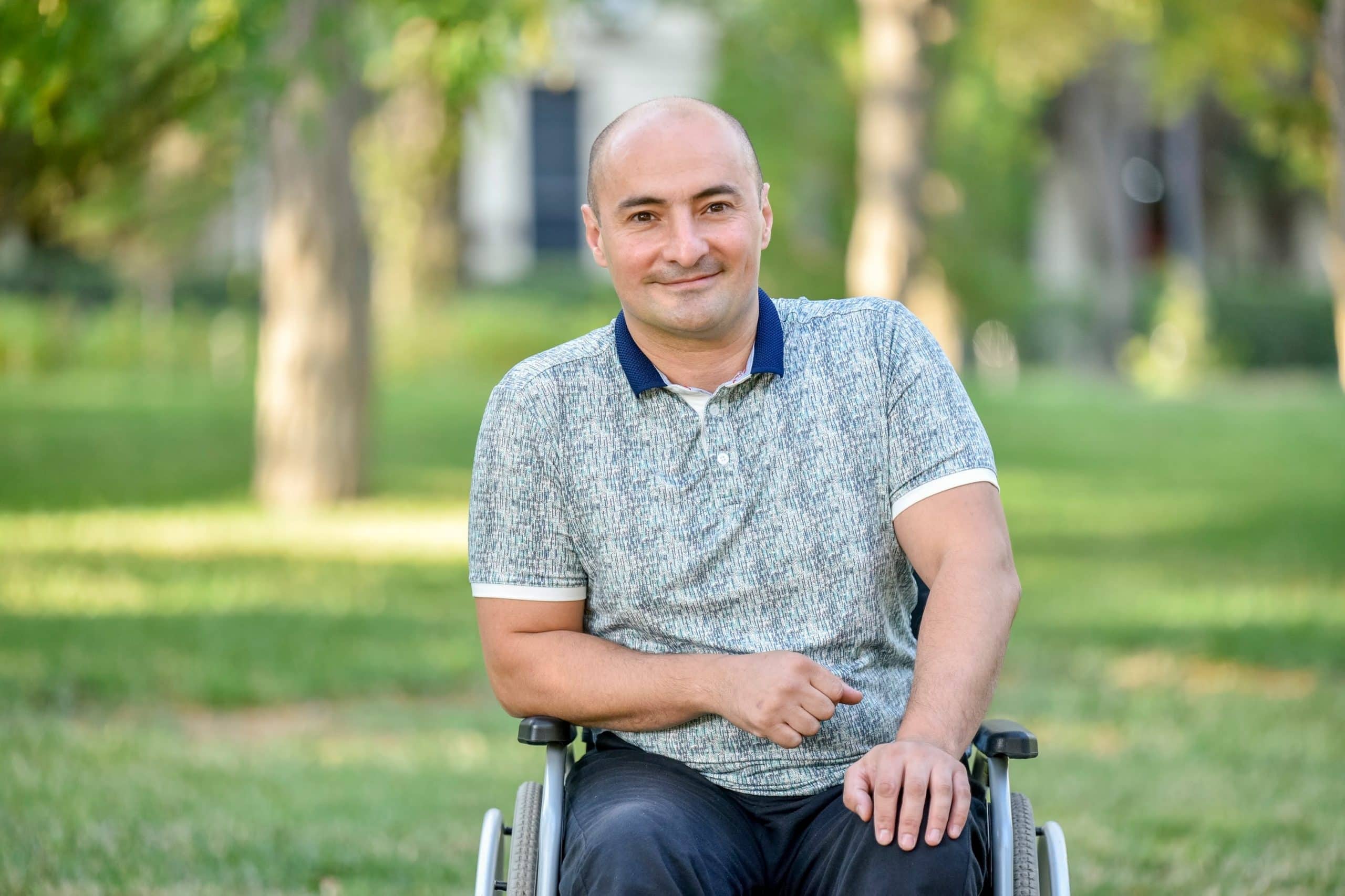 A man sat in his wheelchair with a laptop in front of him. He has had a accident which has resulted to him having spinal cord injury counselling