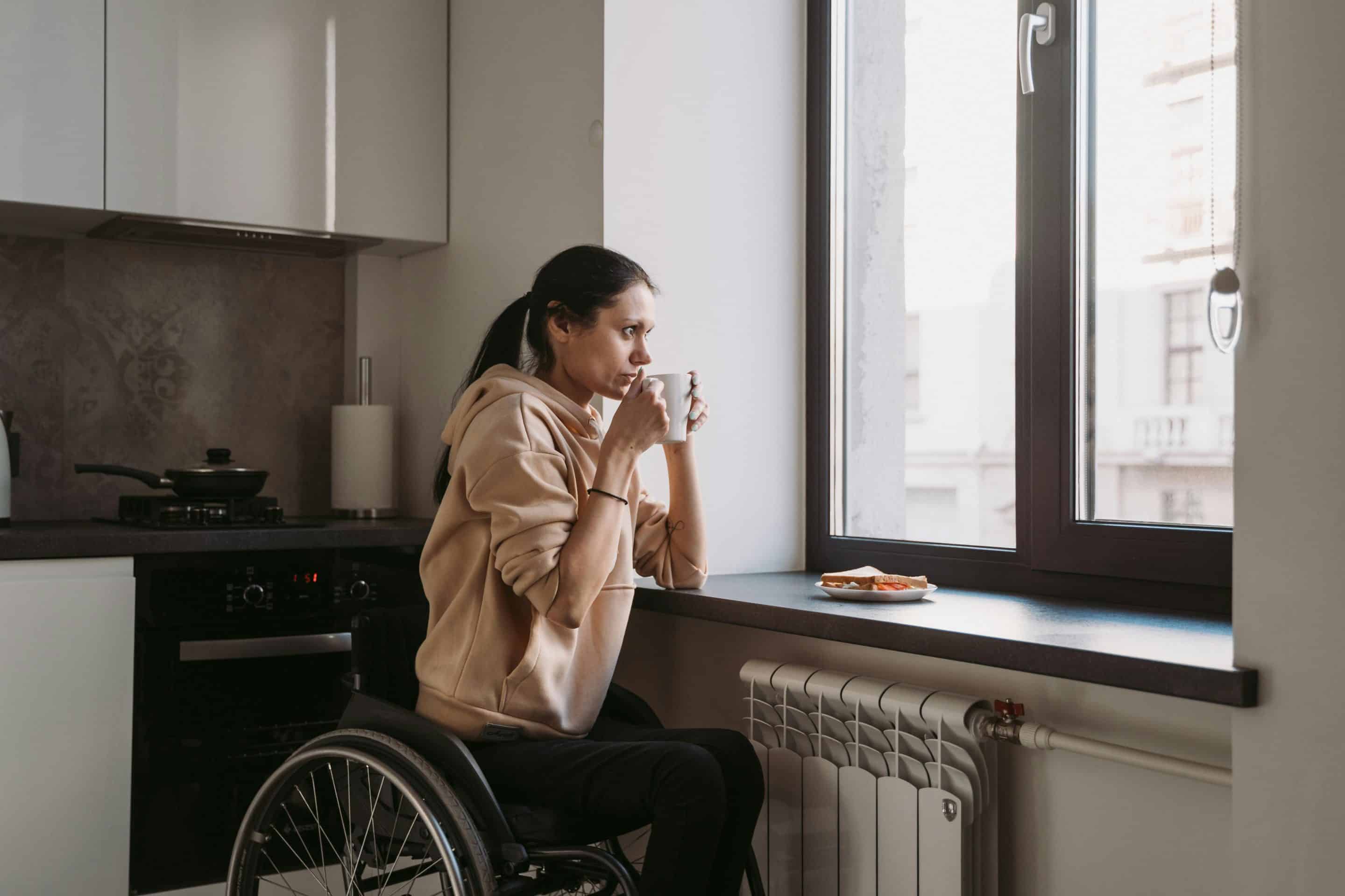 A man sat in his wheelchair with a laptop in front of him. He has had a accident which has resulted to him having spinal cord injury counselling