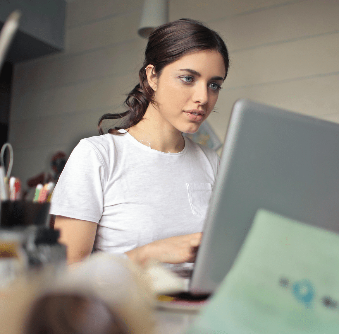 A lady sat at her computer reading the disabilityplus ADHD counselling page.